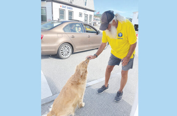 Lake George Steamboat Company Parking Attendant Joel Delaire offers Gracie a treat.