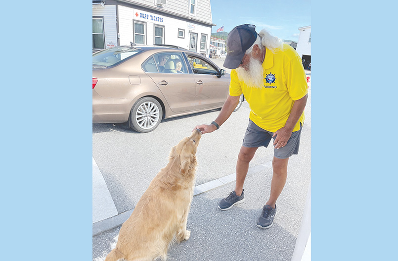 Lake George Steamboat Company Parking Attendant Joel Delaire offers Gracie a treat.